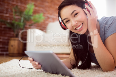 Asian woman using tablet on floor