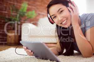 Asian woman using tablet on floor