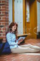 Mature student using tablet in hallway