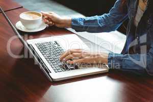 Student using laptop in cafe