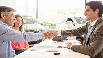 Smiling couple buying a new car