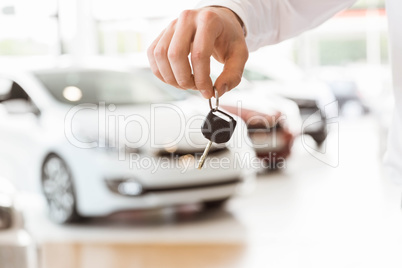 Someone holding car keys by his fingertips