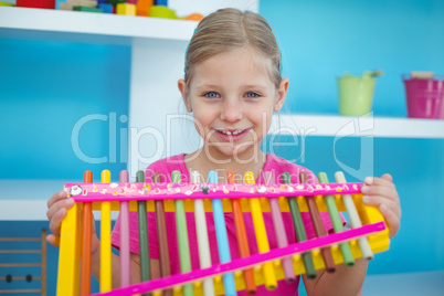 Smiling girl holding a xylophone