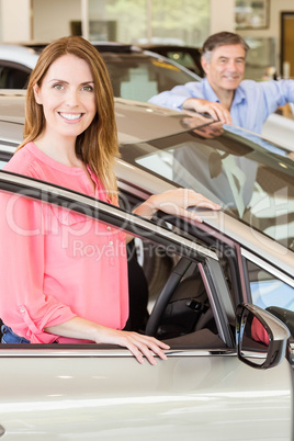 Smiling couple leaning on car