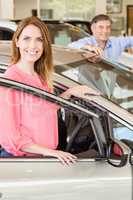 Smiling couple leaning on car