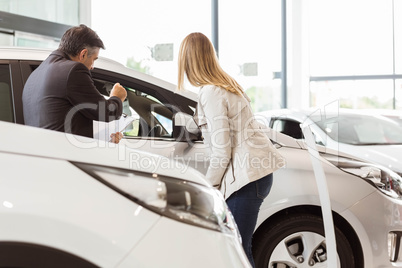 Salesman showing a car to a client