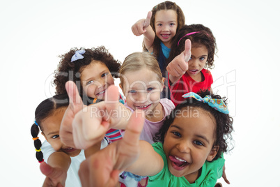 Smiling girls all looking upwards with thumbs up