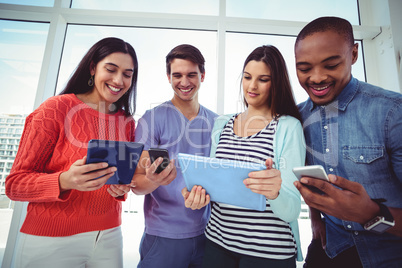 Young creative team looking at phones and tablets