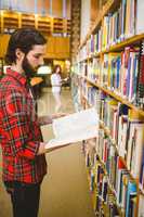 Hipster student picking a book in library