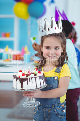 Smiling girl holding birthday cake