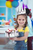 Smiling girl holding birthday cake