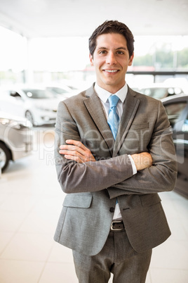 Smiling businessman standing with arms crossed