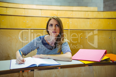 Mature student taking notes in lecture hall