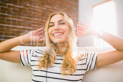 Pretty blonde listening to music on couch