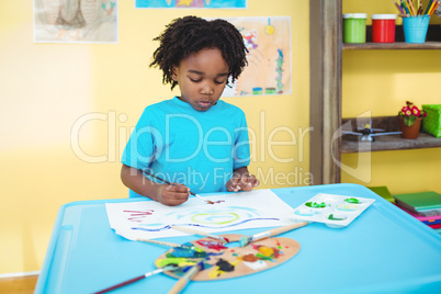 Happy kid painting on a sheet