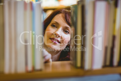 Mature student picking out book in library