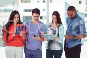 Young creative team looking at phones and tablets