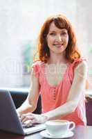 Mature student using laptop in cafe