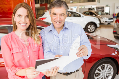 Smiling couple choosing the color of their new car