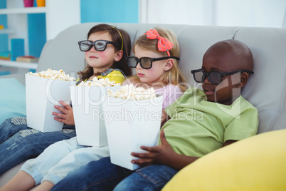 Happy kids sitting together with boxes of popcorn