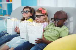 Happy kids sitting together with boxes of popcorn