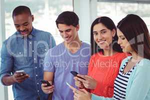 Young creative team looking at phones