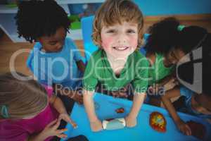 Smiling kids playing with modelling clay