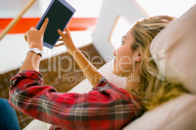 Pretty blonde using tablet on couch Pretty blonde using tablet on couch