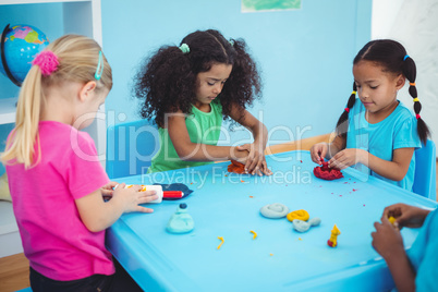 Smiling girls playing with modelling clay