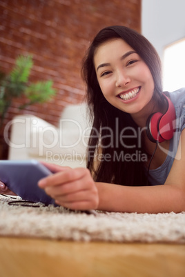 Asian woman using tablet on floor