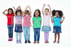 Small group of kids standing together with arms raised