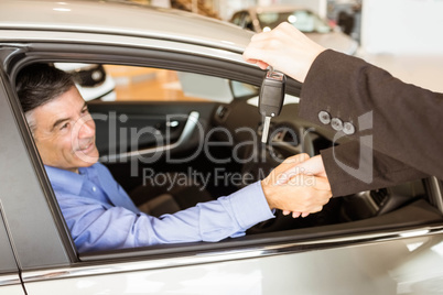 Customer receiving car keys while shaking hand