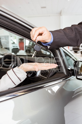 Salesman offering car key to a customers