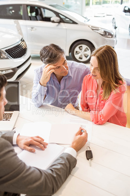 Smiling couple buying a new car