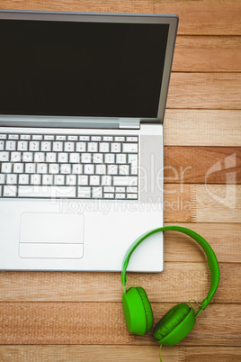 View of a grey laptop with a green headphone