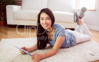 Asian woman using tablet on floor