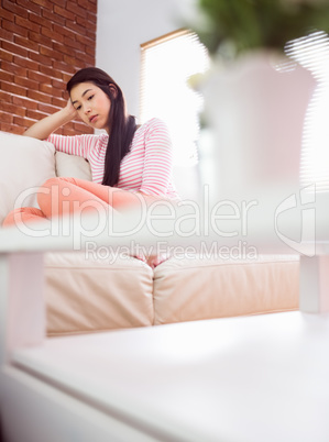 Upset asian woman on couch