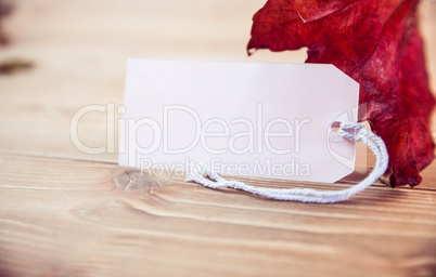 Autumnal leaf on desk with tag