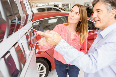 Smiling couple choosing the color of their new car