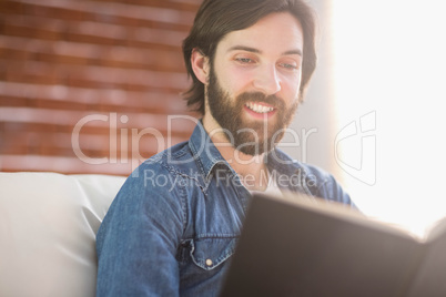 Casual man reading on his sofa