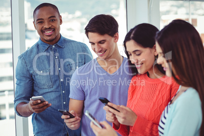 Young creative team looking at phones