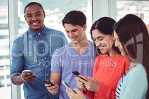 Young creative team looking at phones