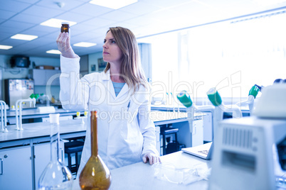 Scientist looking at beaker of chemical