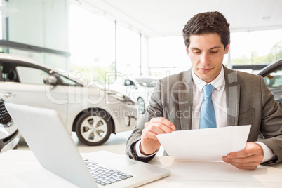 Smiling salesman reading a document