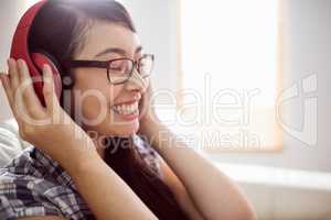 Asian woman on the couch listening to music