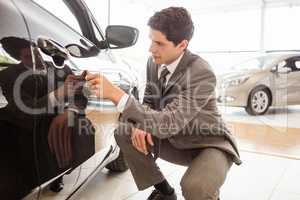 Focused businessman looking at the car body