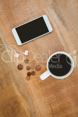 Coffee and white smartphone with headphones