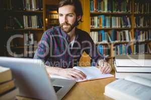 Hipster student studying in library