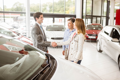 Smiling businessman presenting a car