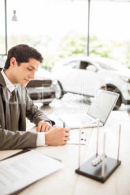 Smiling salesman behind his desk